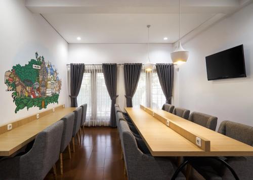 a conference room with chairs and tables and a tv at Kamala House in Yogyakarta