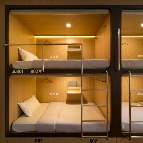 three bunk beds in a small room at Kamala House in Yogyakarta