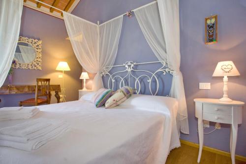 Un dormitorio con una cama blanca con una pared azul. en Villa Gourmet, en Orentano