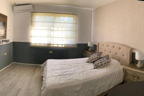 um quarto com uma cama grande e uma janela em PRECIOSO APARTAMENTO DE LUJO AMOBLADO em Chitré