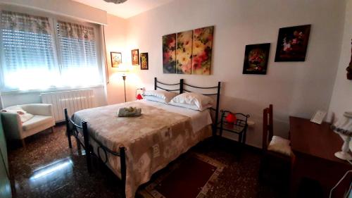 una camera con un letto e una sedia e una finestra di B&B Rosa a Samarate
