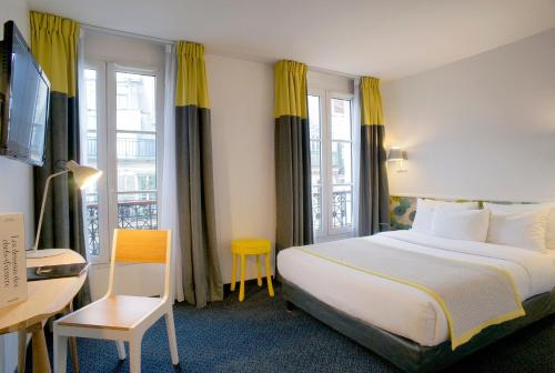 Cette chambre comprend un lit, un bureau et une fenêtre. dans l'établissement Hotel George - Astotel, à Paris