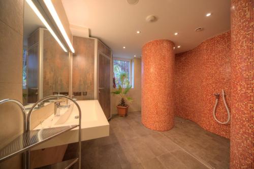 ein Badezimmer mit einer Ziegelwand und einer Säule in der Unterkunft Parkhotel Neubauer in Sauerbrunn