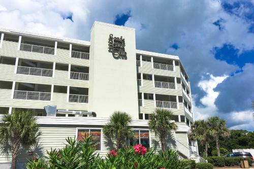 a white building with a clock on the side of it at Sands Beach Club in Myrtle Beach