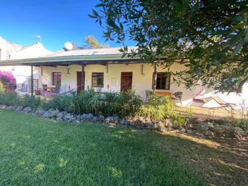 a white house with a lawn in front of it at Bella Manga Country Escape in Plettenberg Bay