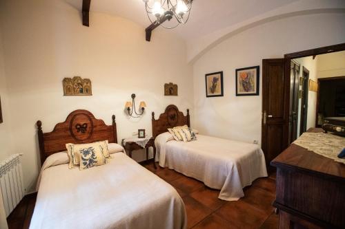 een slaapkamer met 2 bedden en witte lakens bij LA CASONA OLIVENTINA in Olivenza