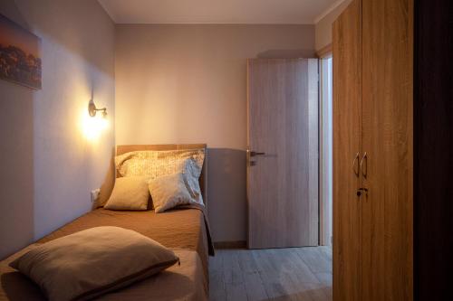 a small bedroom with a bed and a door at Family's nest in Lákka