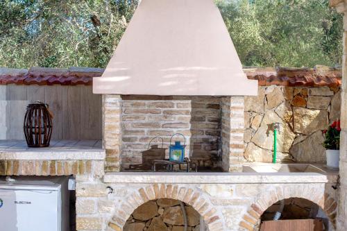 a stone oven in a kitchen with a roof at Family's nest in Lákka