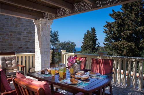 a wooden table with food on a deck with a view at Family's nest in Lákka