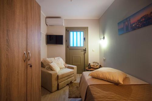 a bedroom with a bed and a chair and a door at Family's nest in Lákka
