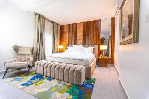 - une chambre avec un lit et une chaise dans l'établissement Isglo Hotels Ikoyi, à Lagos