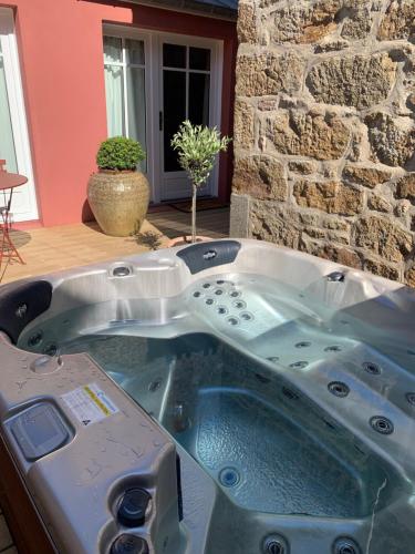 une baignoire jacuzzi dans une chambre avec un mur en pierre dans l'établissement Villa Louisa, à Saint-Malo