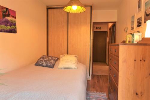 ein kleines Schlafzimmer mit einem Bett und einer Kommode in der Unterkunft HoliApart Żeromskiego 2 in Krynica Morska
