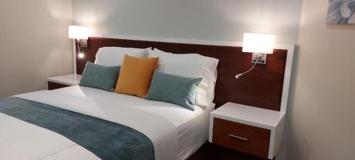 a bedroom with a bed with two lamps on it at Almond Grove at Sand Castle in Ocho Rios