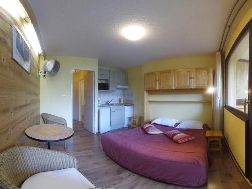 une chambre avec un grand lit et une cuisine dans l'établissement Hôtel les Gardettes, à Orcières