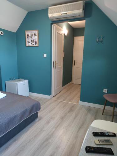 a room with a bed and a blue wall at Jager Guesthouse in Sopron