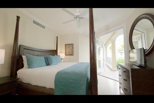 a bedroom with a bed and a mirror and a dresser at Villa Renaissance Grace Bay in The Bight Settlements