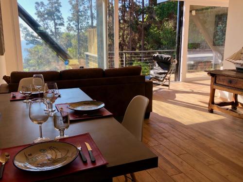a living room with a table with wine glasses and a couch at Lofts - Casa El Pangue, Zapallar in Zapallar