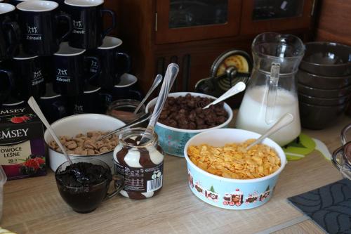 a table with three bowls of cereal and milk at Apartament Dana in Szczyrk