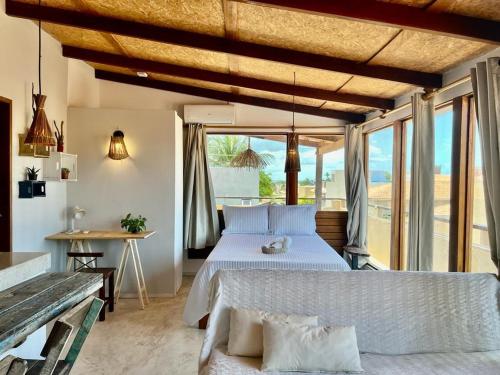 a bedroom with a large bed and a large window at Apê do Fabiano Flats e lofts in Jericoacoara