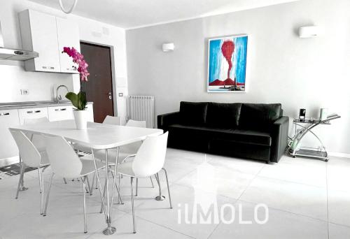 uma sala de estar com uma mesa branca e um sofá preto em Il Molo em Nápoles