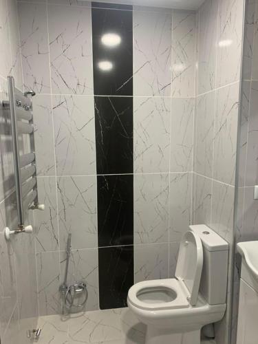 a bathroom with a white toilet and a sink at Kakha's Apartment in Batumi