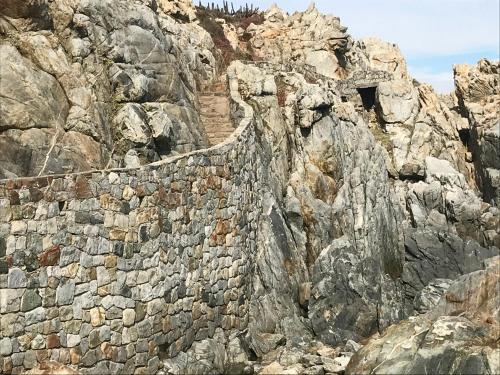 a stone wall on the side of a mountain at Lofts - Casa El Pangue, Zapallar in Zapallar
