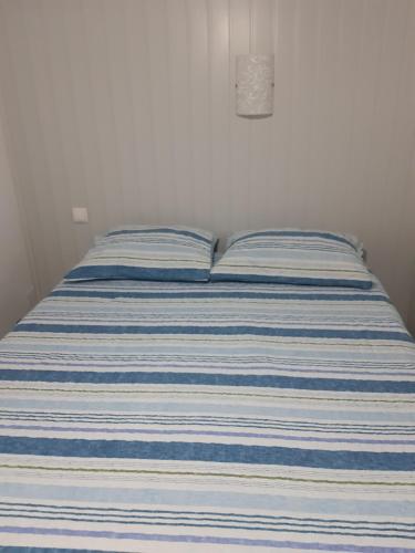 a bed with a blue and white striped mattress at Apartamento Piquinho in Machico
