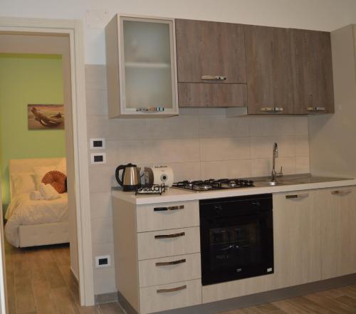 a kitchen with a sink and a stove top oven at Emerella Luxury Suites-Siderno Lungomare in Siderno Marina