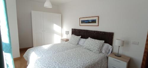 a bedroom with a bed with a white comforter and pillows at Casa Salitre in Hermigua