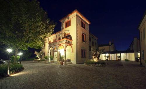 Un grand bâtiment avec des lumières allumées la nuit dans l'établissement Villa dei Tigli 920 Liberty Resort, à Rodigo