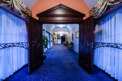 an open door into a hallway with blue carpet at Hotel Wellness & Spa Nowy Dwór in Rzeszów