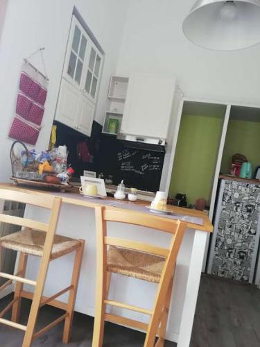 a kitchen with two chairs and a counter in a kitchen at I Vespri in Catania