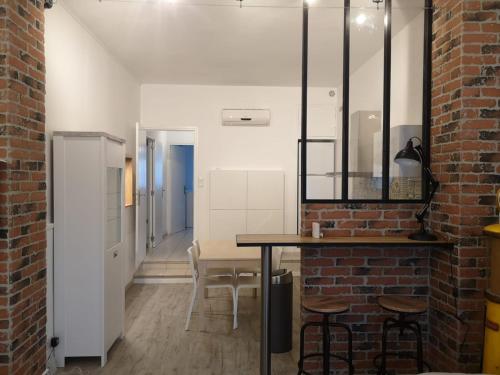 Cette chambre dispose d'une table, de chaises et d'un mur en briques. dans l'établissement Appartement T2 48 m2 indépendant parking public gratuit à proximité, à Béziers