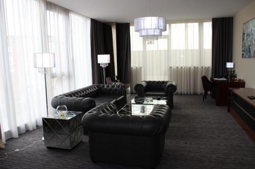 a living room with couches and chairs and windows at Admiral Hotel in Zagreb