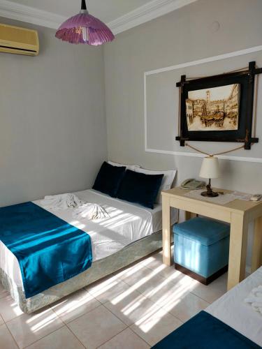 a bedroom with two beds and a table with a lamp at Side Erenler Hotel in Side