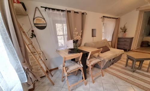 a living room with a table and a couch at Les Rêves d'Eden Gite dans Mas Cévenol -SPA privatif in Carnoulès