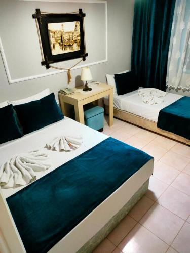 a bedroom with two beds and a table with a mirror at Side Erenler Hotel in Side