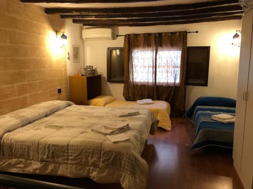 1 dormitorio con 2 camas y ventana en Apartment Bellomia, en Palermo