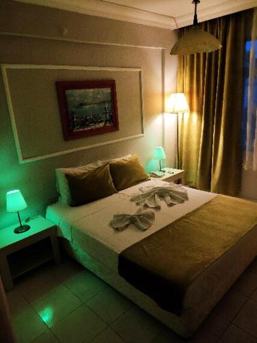 a bedroom with a bed with a green light at Side Erenler Hotel in Side