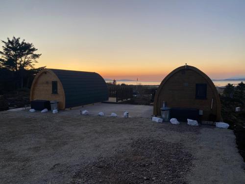 a couple of large domes with the sunset in the background at Arisaig Pods in Arisaig