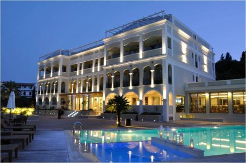 um grande edifício branco com uma piscina em frente em Corfu Mare Hotel -Adults only em Corfu Town