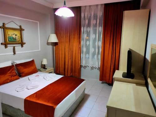 a hotel room with a bed and a television at Side Erenler Hotel in Side