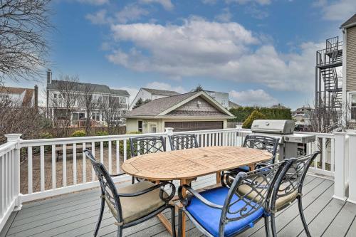 a wooden table and two chairs on a balcony at Beautiful Spacious Beach Home, Private Deck & Grill, with Beach Badges in Point Pleasant Beach
