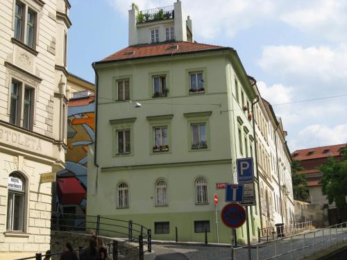 ein gelbes Gebäude mit einem Turm darüber in der Unterkunft Zderaz in Prag