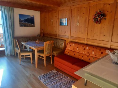 ein Esszimmer mit einem Sofa, einem Tisch und Stühlen in der Unterkunft Vorderkreuzsaalgut Rettenwender Gertraud in Wagrain