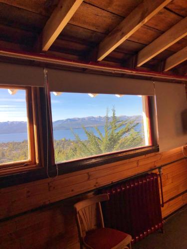 a window in a room with a chair and a view at La Miralejos in San Carlos de Bariloche