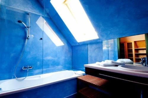 La salle de bains bleue est pourvue d'une baignoire et d'un lavabo. dans l'établissement Hotel Garni Winzerhof Hödl, à Wagna