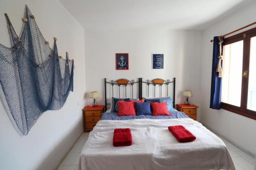 - une chambre avec un lit doté d'oreillers rouges dans l'établissement Sunny Time La Mata, à Torrevieja