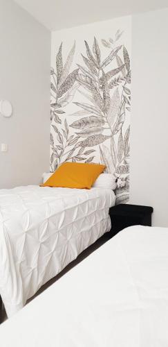 um quarto com 2 camas e um papel de parede tropical em Gîte Evanez Mont-saint-Michel jacuzzi intérieur privatif illimité em Pontorson